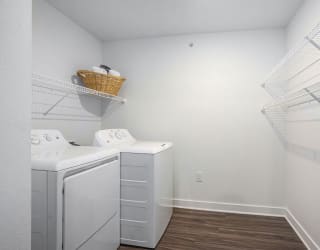 a laundry room with a washer and dryer and a white closet at Meadowbrooke Apartment Homes, Michigan