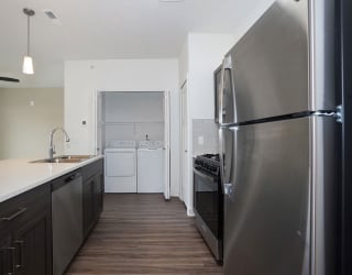 a kitchen with stainless steel appliances and a wooden floor at Meadowbrooke Apartment Homes, Grand Rapids, Michigan