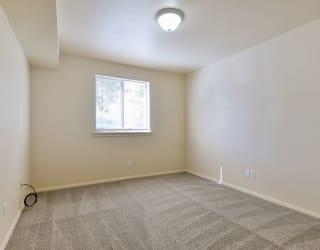 an empty room with carpet and a window at Old Monterey Apartments, Springfield, MO