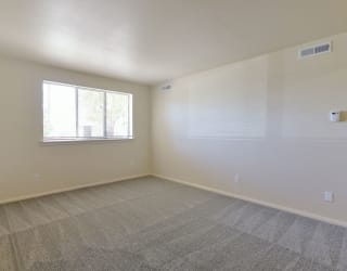 an empty living room with a window and carpet at Old Monterey Apartments, Missouri