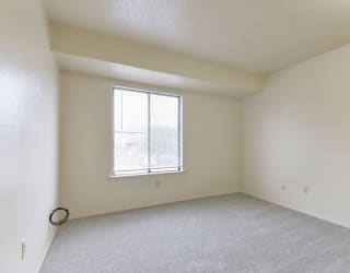 an empty living room with a window and carpet at Old Monterey Apartments, Springfield