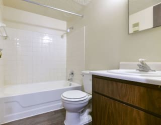 a bathroom with a toilet and a tub and a sink at Old Monterey Apartments, Missouri