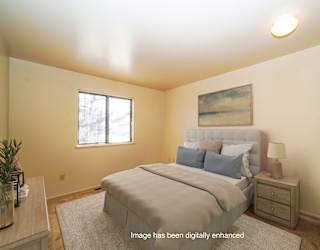 A bedroom with a large bed and a window at Mount Royal Townhomes in Kalamazoo, Michigan