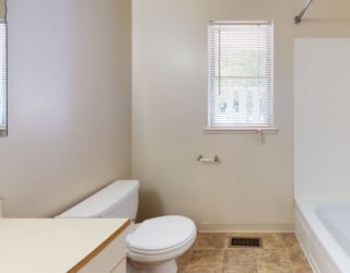 a bathroom with a toilet and a tub and a sink at Mount Royal Townhomes, Kalamazoo, MI