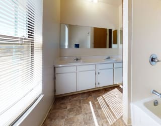 a bathroom with a tub and a sink and a mirror at Mount Royal Townhomes, Michigan