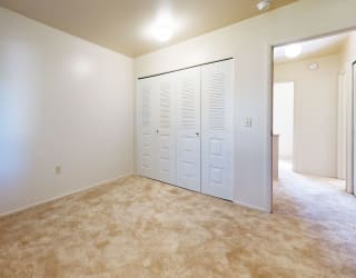 a bedroom with two closets and a carpeted floor at Mount Royal Townhomes, Kalamazoo, 49009