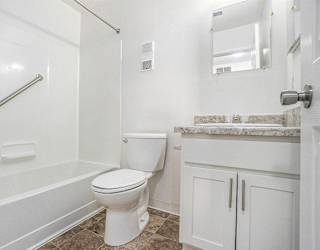 An upgraded bathroom with a shower and bathtub at Newport Village Apartments, Portage, MI