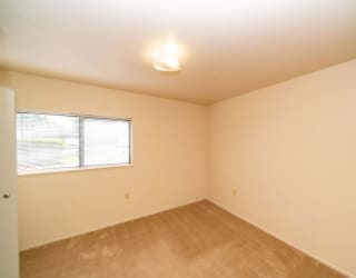 an empty room with a window and carpet at North Pointe Apartments, Elkhart
