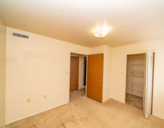 an empty living room with a closet and a door to a bathroom at North Pointe Apartments, Elkhart, IN