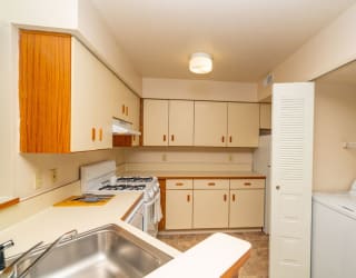 an empty kitchen with white appliances and white cabinets at North Pointe Apartments, Indiana, 46514