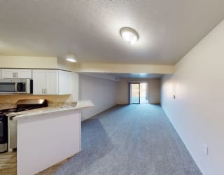 a kitchen with a counter top and a large living room at North Pointe Apartments, Indiana, 46514