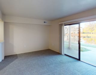 a living room, kitchen and a sliding glass door to a patio at North Pointe Apartments in Elkhart, IN