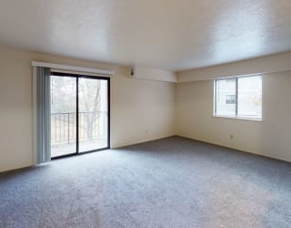 an empty living room with a sliding glass door to a balconyat North Pointe Apartments, Indiana, 46514
