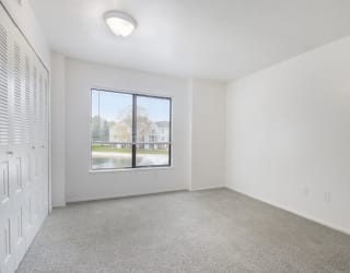 a bedroom with carpet and large window at North Pointe Apartments in Elkhart, IN
