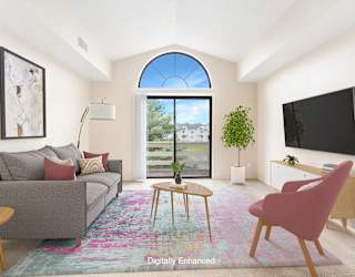 A living room with a cathedral ceiling and a slider to a private balcony at North Pointe Apartments, Elkhart