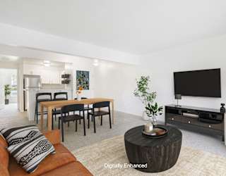A modern living room with a wooden coffee table and a flat screen TV at North Pointe Apartments, Indiana, 46514