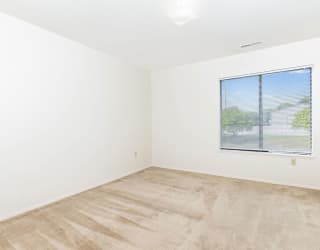 an empty room with a window and white walls  at Oak Shores Apartments, Oak Creek, 53154