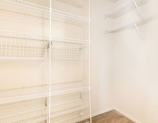 a white closet with empty shelves in a room  at Oak Shores Apartments, Oak Creek, 53154