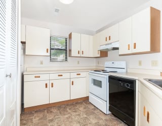 a kitchen with white cabinets and a stove and a oven  at Oak Shores Apartments, Oak Creek, Wisconsin