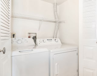 a white washer and dryer in a laundry room with a white closet  at Oak Shores Apartments, Oak Creek, WI, 53154