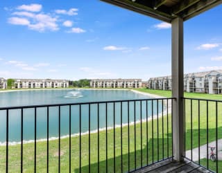 a balcony with a view of a lake and some apartment buildings  at Oak Shores Apartments, Oak Creek, WI