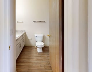 an empty bathroom with a toilet and a sink  at Oak Shores Apartments, Oak Creek, WI