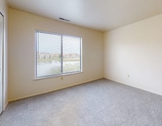 an empty room with a window and carpeting  at Oak Shores Apartments, Oak Creek, Wisconsin