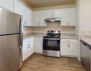a kitchen with stainless steel appliances and white cabinets  at Oak Shores Apartments, Oak Creek, 53154