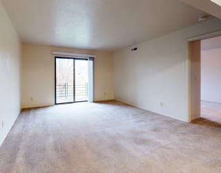 an empty living room with a door to a balcony at Pine Knoll Apartments, Michigan, 49014