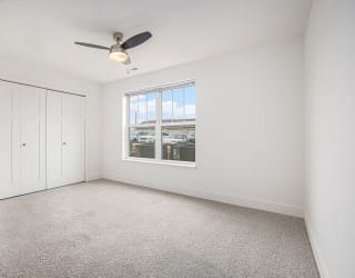 Bedroom with a ceiling fan and large windows  at Signature Pointe Apartment Homes, Athens, Alabama