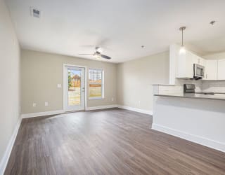 living room and kitchen with a door to a private patio  at Signature Pointe Apartment Homes, Alabama