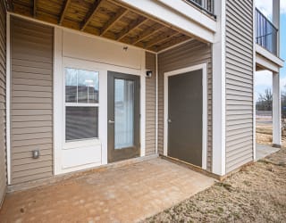 the patio of an apartment with a door to enclosed storage  at Signature Pointe Apartment Homes, Alabama, 35611