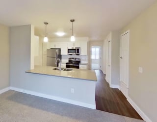 living room leading into a kitchen at Signature Pointe Apartment Homes in Athens, AL