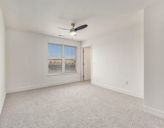 Large bedroom with a ceiling fan and a large window  at Signature Pointe Apartment Homes, Athens, Alabama