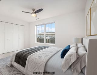 Spacious bedroom with ceiling fan and large window at Signature Pointe Apartment Homes in Athens, AL