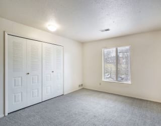 an empty living room with a window and a closet at South Bridge Apartments, Fort Wayne, IN