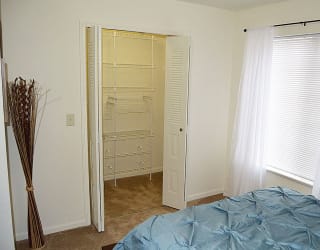 a bedroom with an empty closet and a bed at Stoney Pointe Apartment Homes, Wichita, KS, 67226