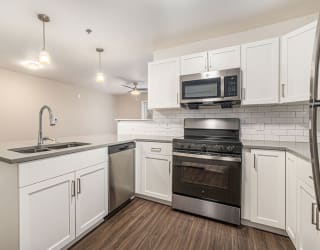 a kitchen with white cabinets and stainless steel appliances at Stoney Pointe Apartment Homes, Wichita, KS
