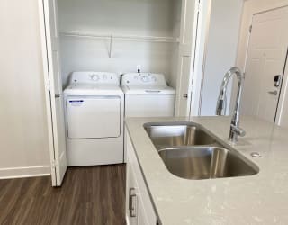 a kitchen with a sink and a washer and dryerat Stoney Pointe Apartment Homes, Kansas, 67226