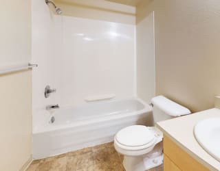a bathroom with a sink toilet and a tub at Swiss Valley Apartments, Wyoming, MI, 49509