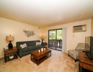a living room with a couch and a television at Swiss Valley Apartments, Wyoming, MI
