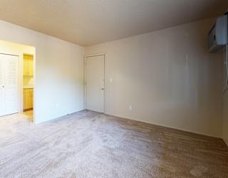 A garden style living room with a carpeted floor at Swiss Valley Apartments in Wyoming, MI