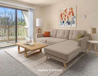 A living room with plush carpet and a slider to a balcony at Swiss Valley Apartments, Wyoming, MI