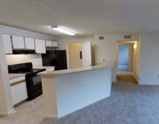 A kitchen with black appliances and white cabinets.