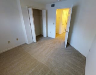 A room with a carpeted floor and two open doors.