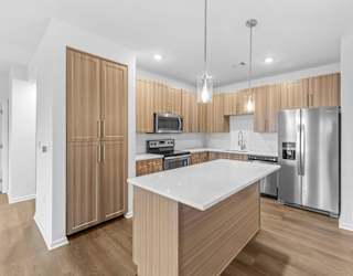 A modern kitchen with wooden cabinets and stainless steel appliances.