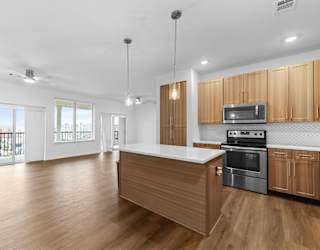 A kitchen with wooden cabinets and a stainless steel oven.