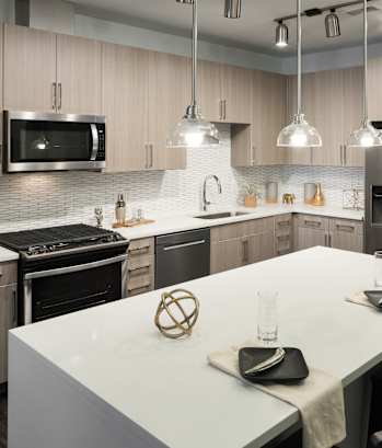a kitchen with a large white island and stainless steel appliances