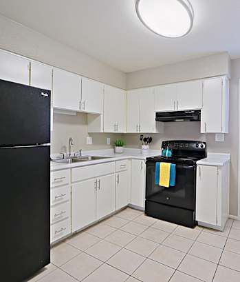 a kitchen with white cabinets and black appliances