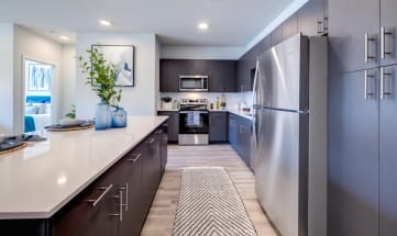 a large kitchen with stainless steel appliances and white counter tops
